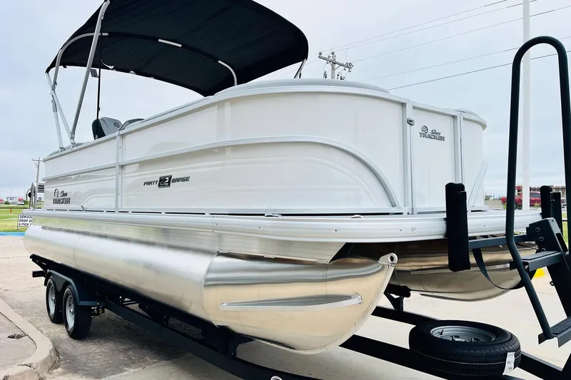 Slide: The Image of 2026 Sun Tracker Party Barge 22 DLX pontoon boat on trailer, side view. - 4