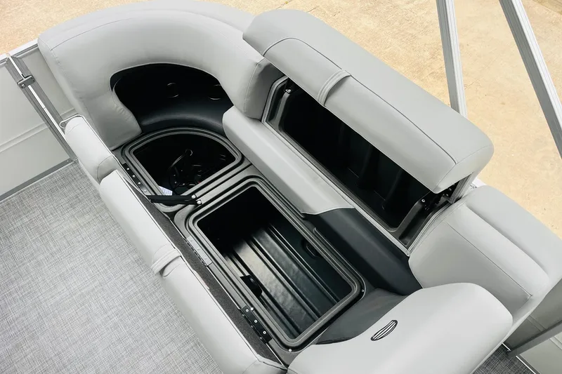 Slide: The Image of 2026 Sun Tracker Party Barge 22 DLX, open storage compartments, gray seating, boat interior. - 41