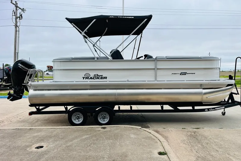 Slide: The Image of 2026 Sun Tracker Party Barge 22 DLX pontoon boat on trailer, side view. - 5