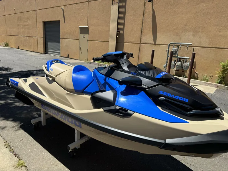 Slide: The Image of 2025 Sea-Doo Wake Pro 230 jet ski in blue and beige, parked outdoors. - 3