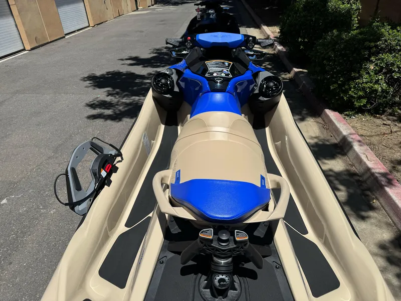Slide: The Image of 2025 Sea-Doo Wake Pro 230 jet ski in a trailer, parked on a sunny street. - 4