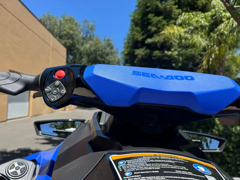 Slide: The Image of 2025 Sea-Doo Wake Pro 230 handlebars and controls, outdoor setting. - 7