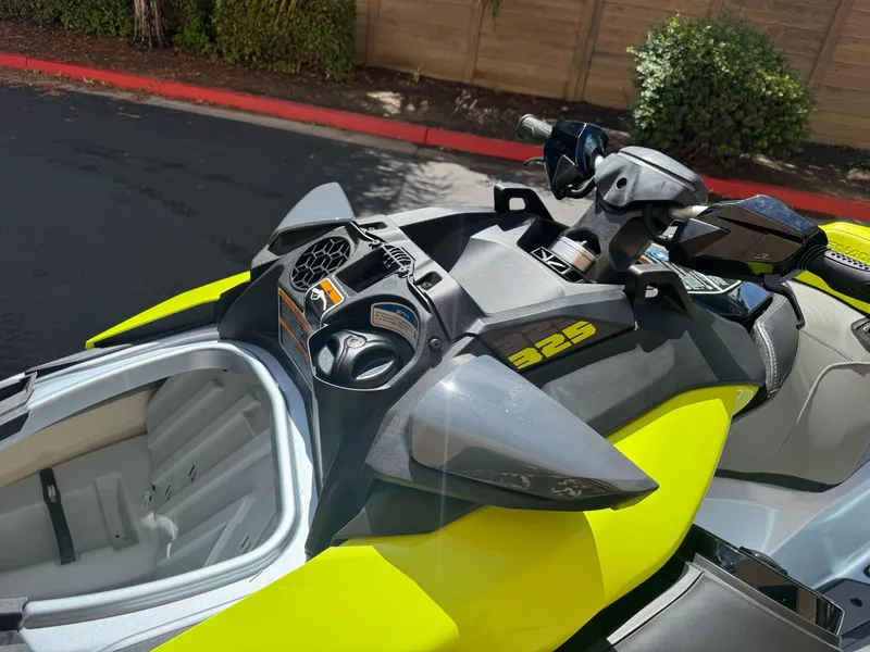 Slide: The Image of 2025 Sea-Doo RXP-X 325 jet ski, vibrant yellow, close-up of handlebars and storage compartment. - 9