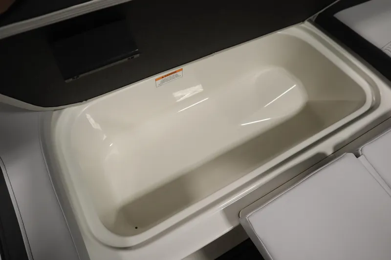 Slide: The Image of 2025 Bayliner M15 MX COMFORT PACKAGE storage compartment, open and empty, with cushioned seating. - 14