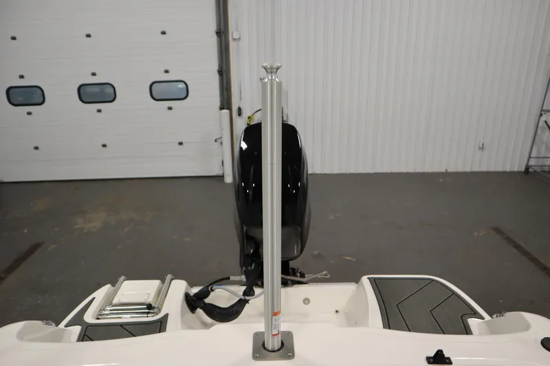 Slide: The Image of 2025 Bayliner M15 MX boat in a garage, showcasing rear view and motor. - 26