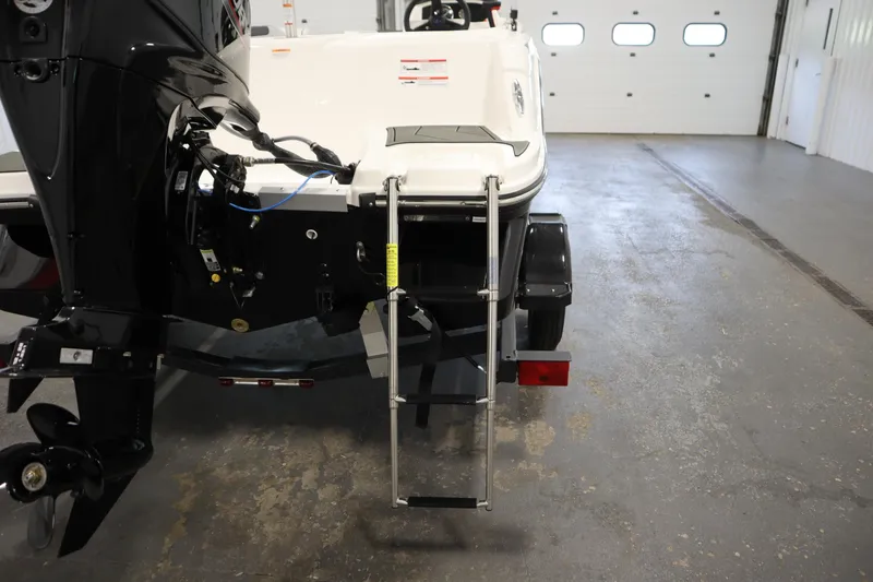 Slide: The Image of 2025 Bayliner M15 MX COMFORT PACKAGE boat with ladder and motor in a garage. - 28