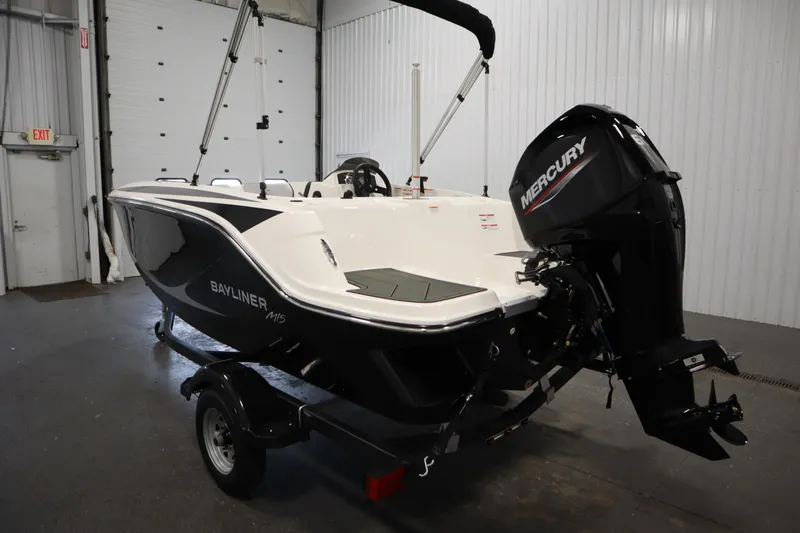 Slide: The Image of 2025 Bayliner M15 MX Comfort Package boat with Mercury engine in a garage. - 7