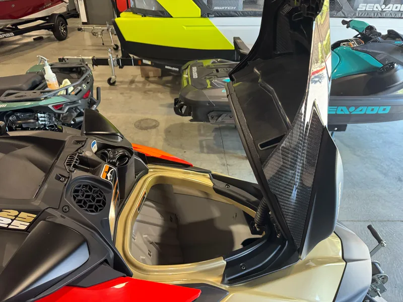 Slide: The Image of 2025 Sea-Doo RXP-X 325 with open storage compartment in a showroom. - 9