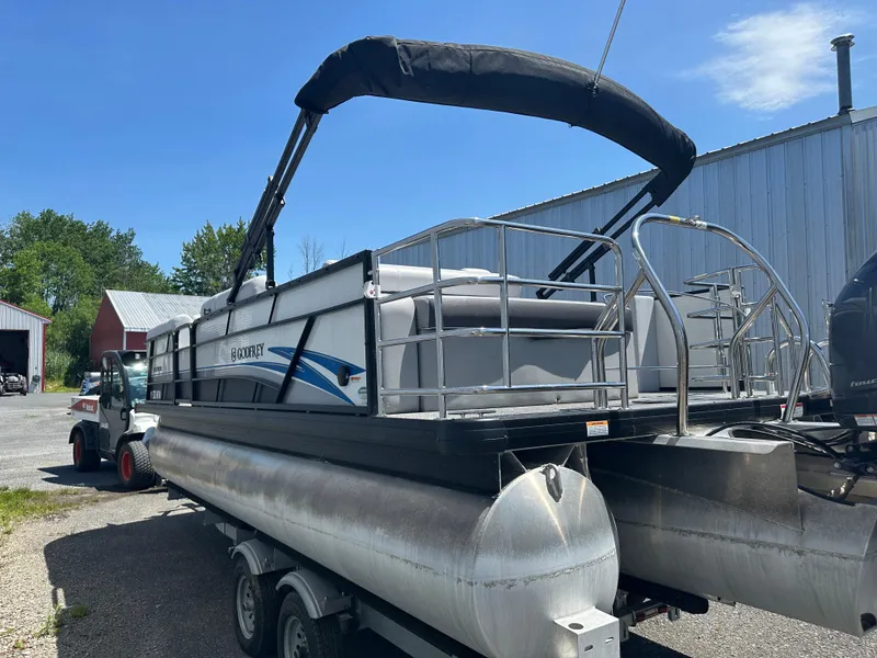 Slide: The Image of 2022 Godfrey SWEETWATER 2286 SFL pontoon boat on trailer, parked outdoors. - 2