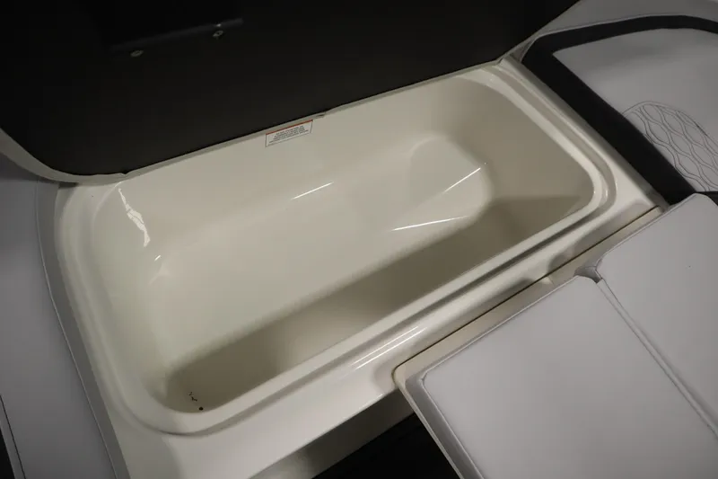 Slide: The Image of 2024 Bayliner M15 MX Comfort Package storage compartment, open and empty. - 13