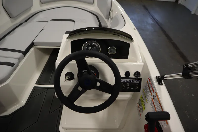 Slide: The Image of 2024 Bayliner M15 MX COMFORT PACKAGE boat interior with steering wheel and dashboard controls. - 16