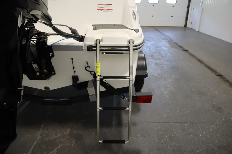 Slide: The Image of 2024 Bayliner M15 MX COMFORT PACKAGE boat with rear ladder in a garage. - 26