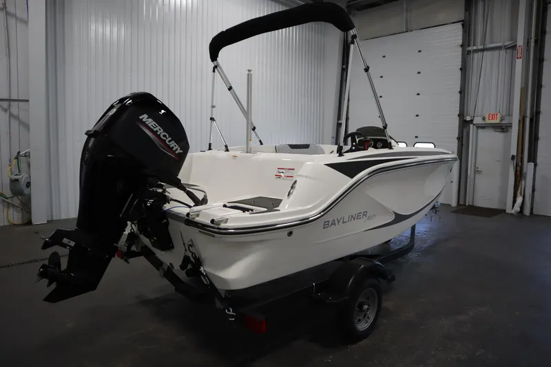 Slide: The Image of 2024 Bayliner M15 MX Comfort Package boat with Mercury engine in a garage setting. - 5