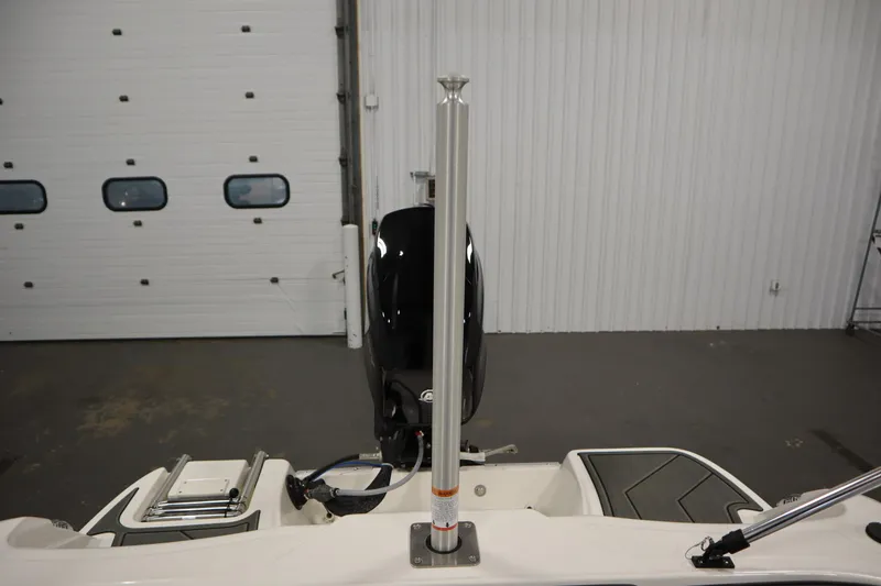Slide: The Image of 2025 Bayliner Element M15 boat interior with motor and pole, in a garage setting. - 24