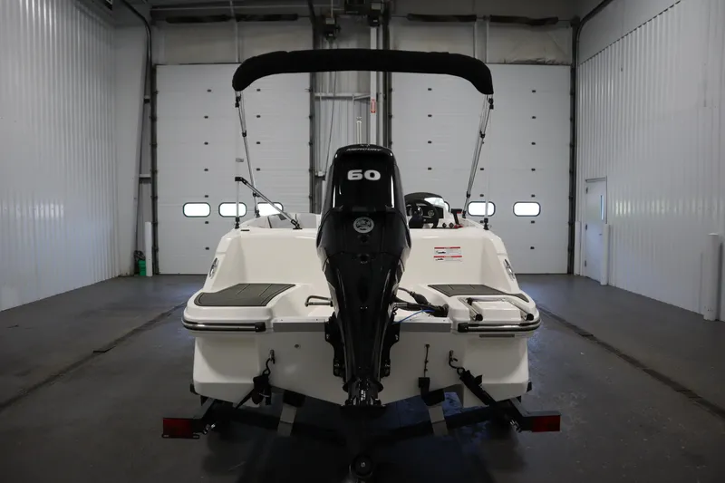 Slide: The Image of 2025 Bayliner Element M15 boat in a garage, rear view with outboard motor. - 6