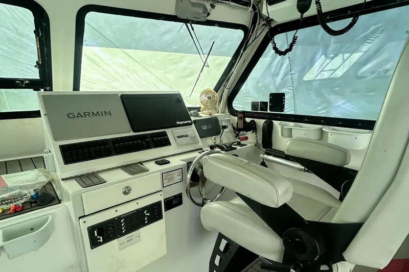 Slide: The Image of 2016 Newton Sportfish boat cockpit with Garmin navigation system and white seating. - 10