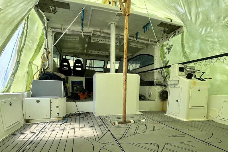 Slide: The Image of 2016 Newton Sportfish boat interior under tarp, featuring seating and fishing equipment. - 4
