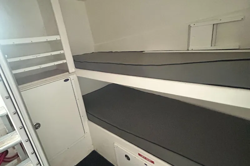 Slide: The Image of Interior of a 2016 Newton Sportfish boat with bunk beds and storage. - 5