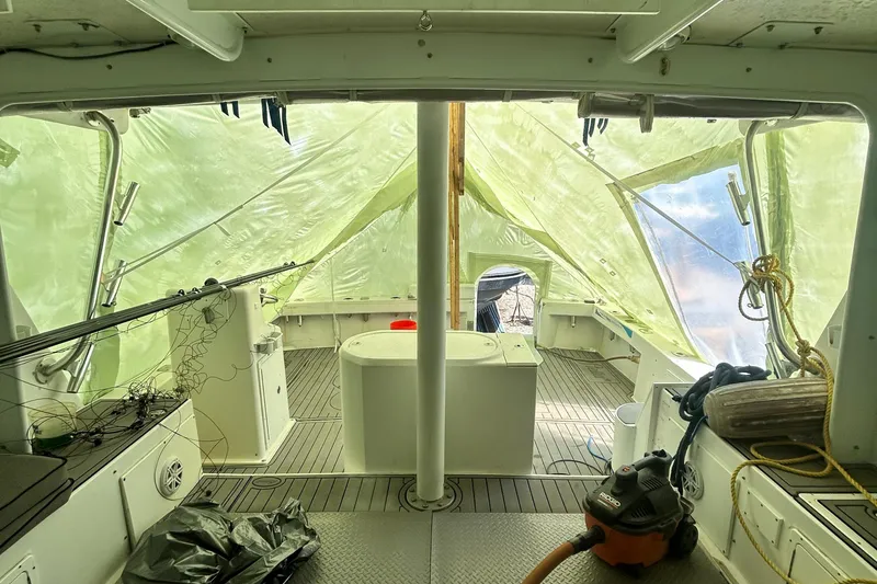 Slide: The Image of Interior of a 2016 Newton Sportfish boat under tarp, showing deck and equipment. - 7