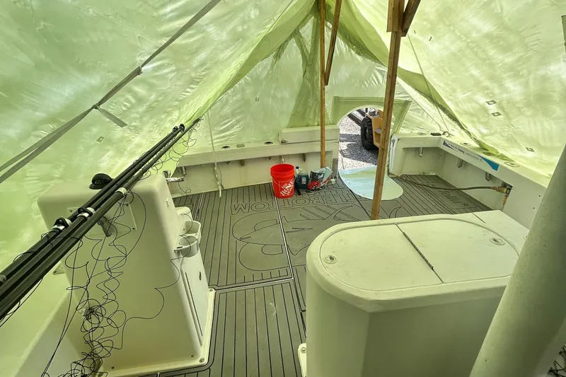 Slide: The Image of 2016 Newton Sportfish boat interior under tarp, featuring fishing rods and equipment. - 9