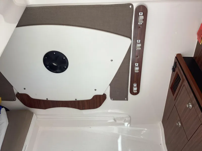 Slide: The Image of 2017 Pursuit DC 325 Dual Console interior with wood accents and storage compartments. - 14