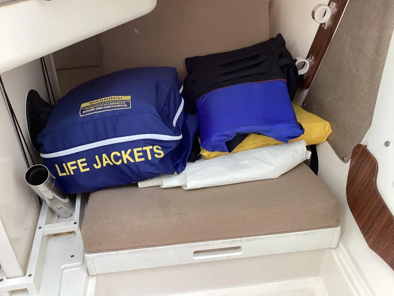 Slide: The Image of Life jackets stored on a 2017 Pursuit DC 325 Dual Console boat seat. - 15
