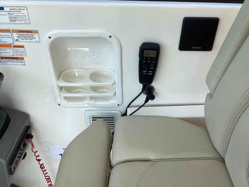 Slide: The Image of 2017 Pursuit DC 325 Dual Console interior with cup holders, radio, and Garmin speaker. - 21