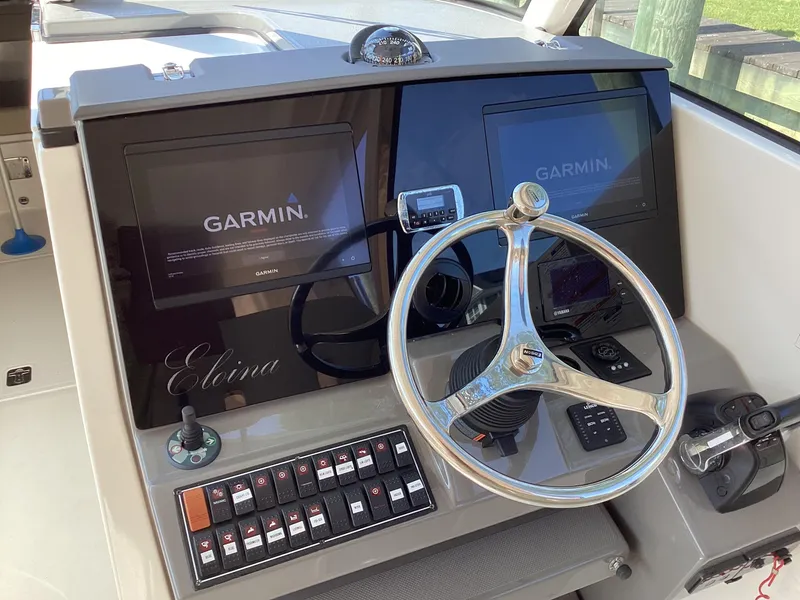 Slide: The Image of 2017 Pursuit DC 325 Dual Console helm with Garmin displays and steering wheel. - 23