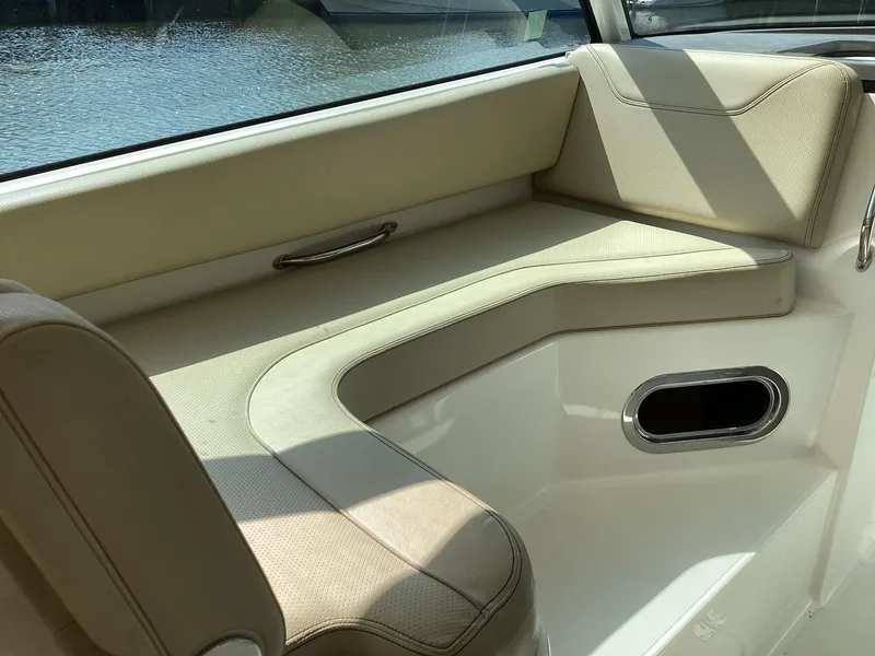 Slide: The Image of 2017 Pursuit DC 325 Dual Console interior with beige seating and water view. - 24