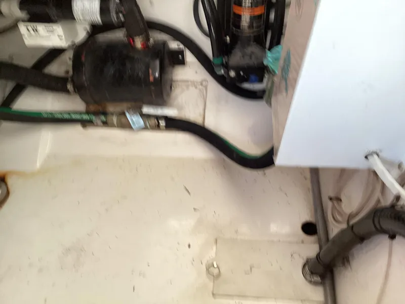 Slide: The Image of Engine compartment of a 2017 Pursuit DC 325 Dual Console boat, showing hoses and components. - 29