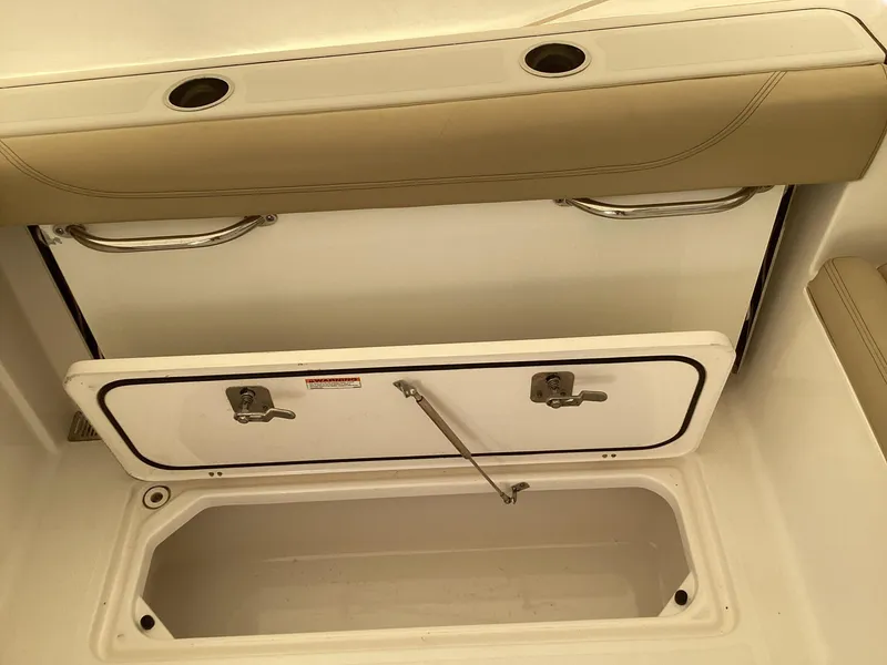 Slide: The Image of 2017 Pursuit DC 325 Dual Console storage compartment with open hatch and cushioned seating. - 36