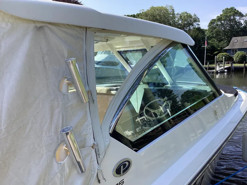 Slide: The Image of 2017 Pursuit DC 325 Dual Console boat docked, featuring sleek design and covered seating area. - 39