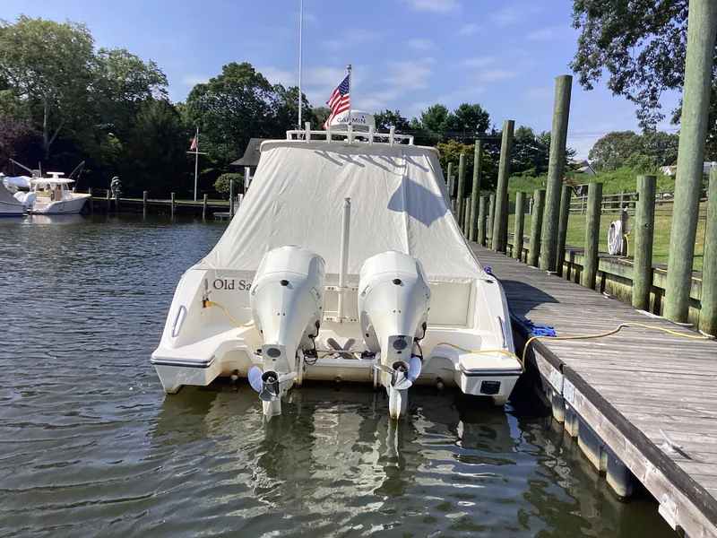 Slide: The Image of 2017 Pursuit DC 325 Dual Console boat docked with cover and twin outboard motors. - 42
