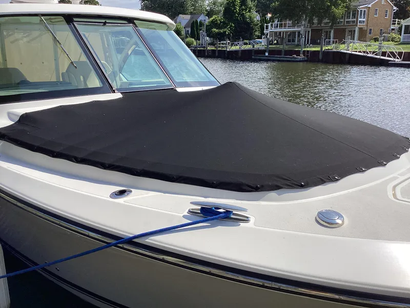 Slide: The Image of 2017 Pursuit DC 325 Dual Console boat with black cover, docked by a waterfront home. - 9