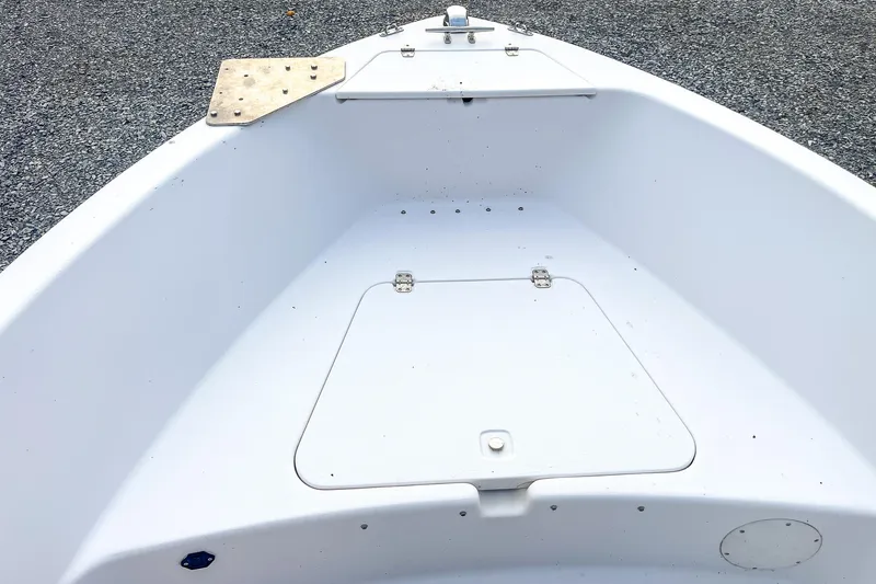Slide: The Image of Bow of 2000 Pro-Line 20 Sport boat with storage compartment, on gravel surface. - 13