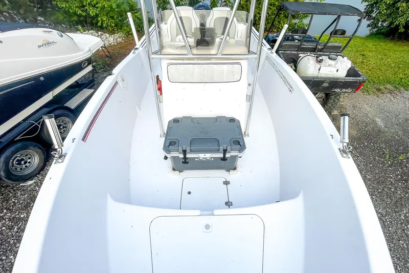 Slide: The Image of 2000 Pro-Line 20 Sport boat interior with cooler, parked on gravel near other vehicles. - 15