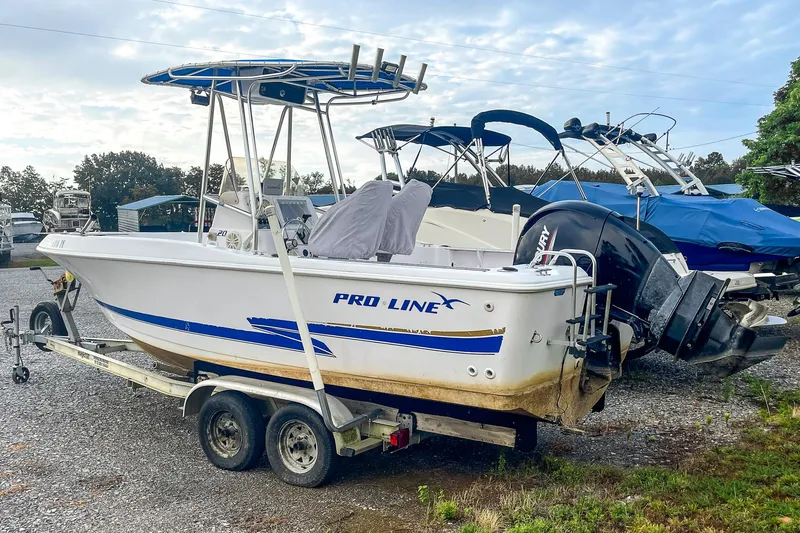Slide: The Image of 2000 Pro-Line 20 Sport boat on trailer, parked outdoors with other boats. - 3