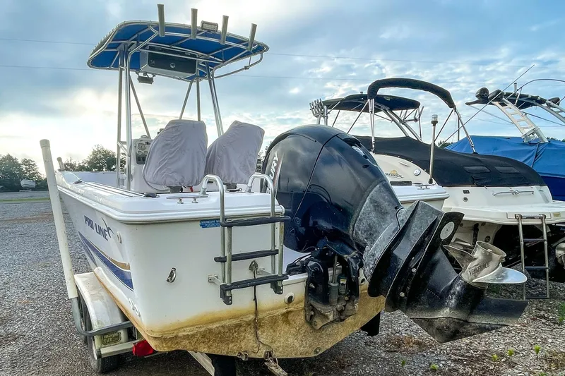 Slide: The Image of 2000 Pro-Line 20 Sport boat with outboard motor on trailer, parked outdoors. - 4