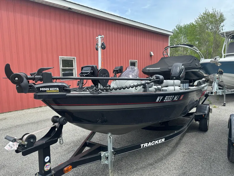 Slide: The Image of 2013 Tracker Super Guide V-16 SC fishing boat on trailer, parked near a red building. - 8