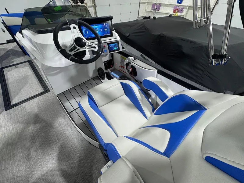 Slide: The Image of 2025 Montara Surf Boss boat interior with blue and beige seating, cup holders, and speakers. - 11