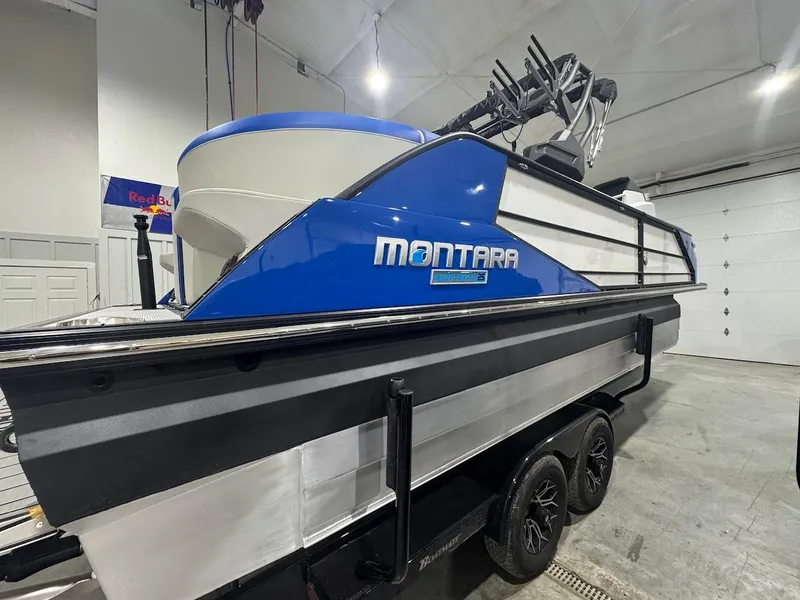 Slide: The Image of 2025 Montara Surf Boss boat in showroom, blue and white design on trailer. - 4
