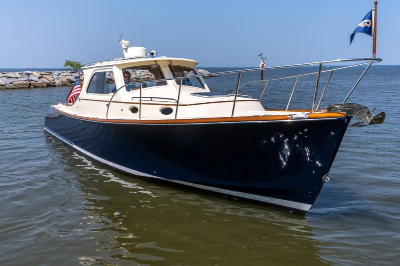 Slide: The Image of 2007 Hinckley Picnic Boat EP on calm water, featuring sleek design and American flag. - 10