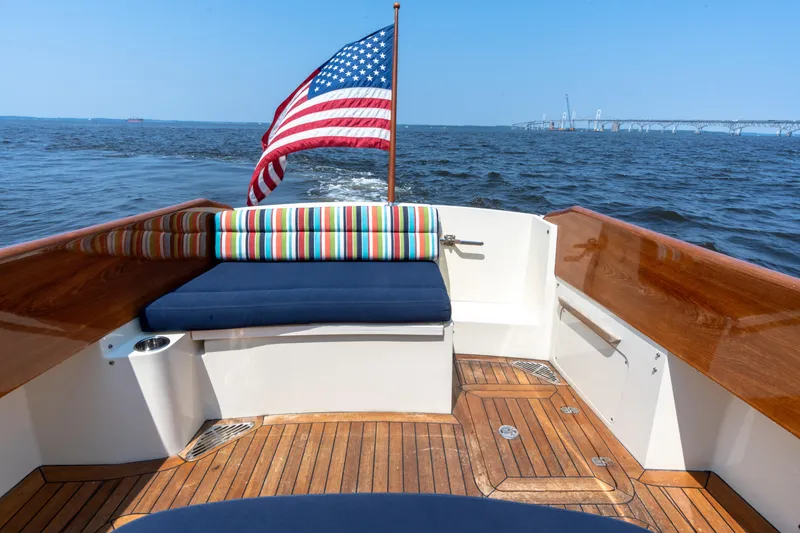 Slide: The Image of 2007 Hinckley Picnic Boat EP with American flag, wooden deck, and colorful seating on open water. - 18