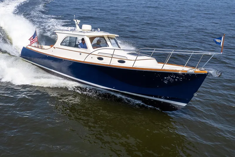 Slide: The Image of 2007 Hinckley Picnic Boat EP cruising on open water, displaying sleek design and American flag. - 2