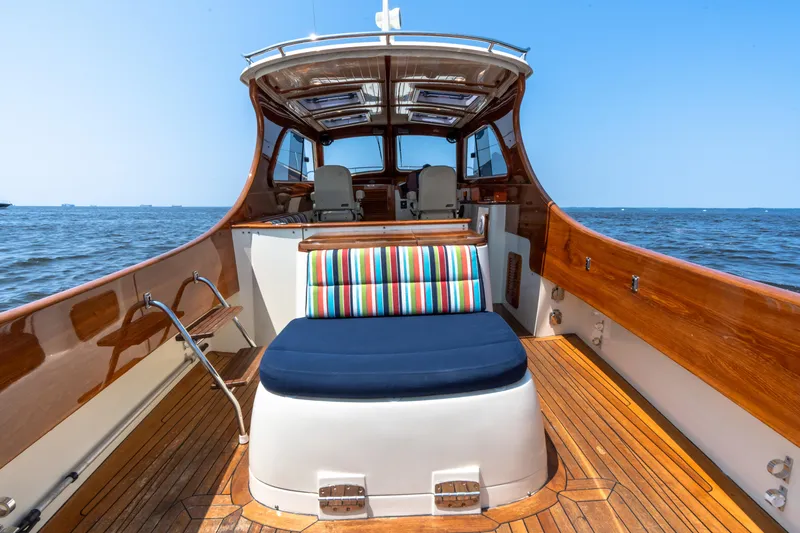 Slide: The Image of 2007 Hinckley Picnic Boat EP with wooden deck and colorful seating on open water. - 21