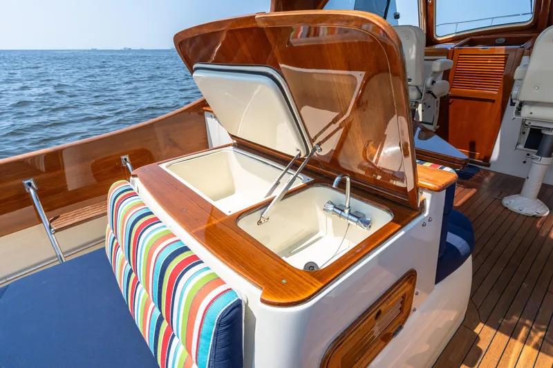 Slide: The Image of 2007 Hinckley Picnic Boat EP interior with open sink, colorful seating, and wooden accents. - 23