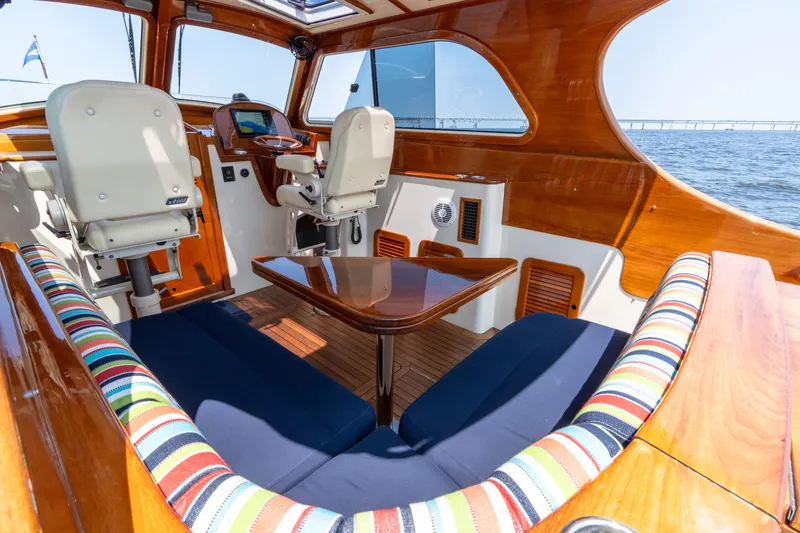 Slide: The Image of Luxurious 2007 Hinckley Picnic Boat EP interior with striped seating and wooden accents. - 25