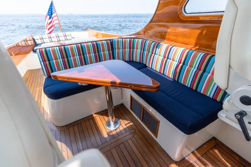 Slide: The Image of 2007 Hinckley Picnic Boat EP interior with striped seating and wooden table. - 28
