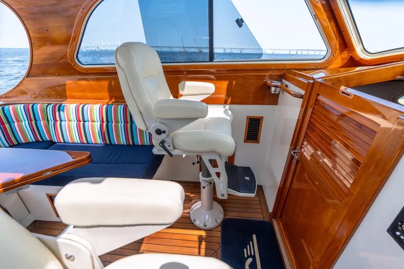 Slide: The Image of Interior of 2007 Hinckley Picnic Boat EP with striped seating and wooden finishes. - 30