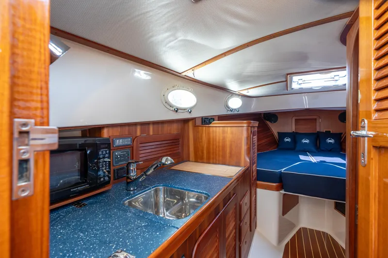 Slide: The Image of 2007 Hinckley Picnic Boat EP interior with kitchenette, sink, and cozy sleeping area. - 37
